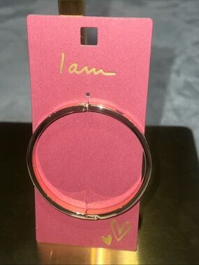 I Am" brand gold-tone openable bangle bracelet decorated with red hearts.
